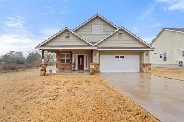 craftsman inspired home with a garage, covered porch, driveway, stone siding, and a front yard