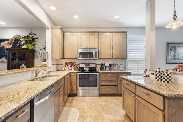 kitchen with hanging light fixtures, decorative backsplash, stainless steel appliances, and a sink