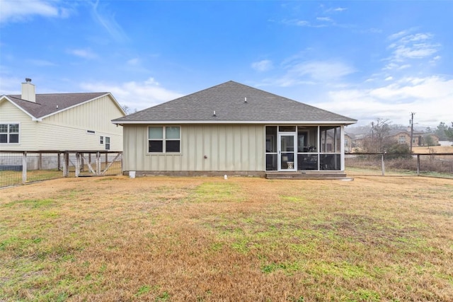 rear view of property with a lawn, a sunroom, a fenced backyard, roof with shingles, and board and batten siding