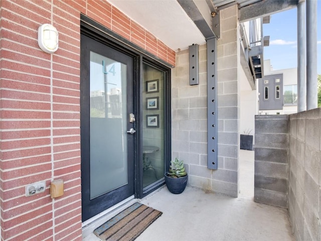 view of exterior entry featuring brick siding