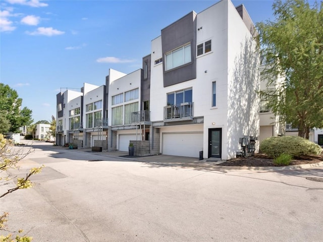 view of building exterior featuring an attached garage and a residential view