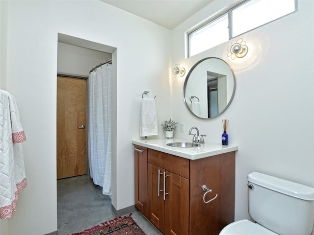 bathroom with concrete floors, vanity, and toilet