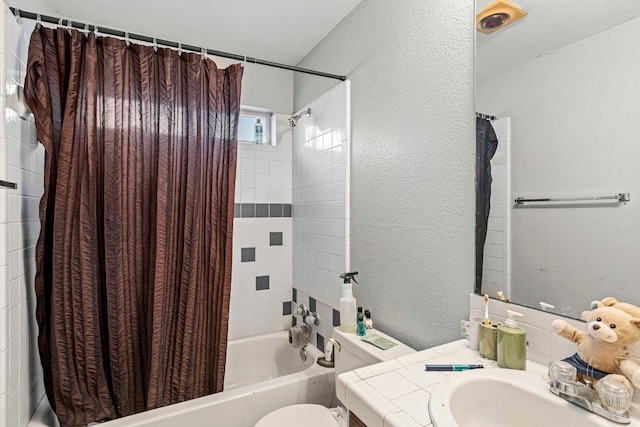 full bathroom with a textured wall, vanity, toilet, and shower / bath combo with shower curtain