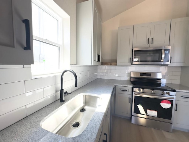 849 Cypress Ln, Cottonwood Shores, TX 78657 - kitchen with appliances with stainless steel finishes, decorative backsplash, lofted ceiling, and light countertops