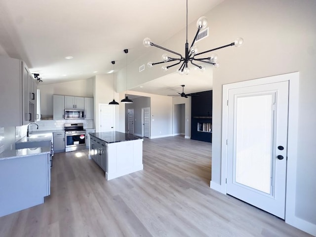 849 Cypress Ln, Cottonwood Shores, TX 78657 - kitchen featuring appliances with stainless steel finishes, a chandelier, high vaulted ceiling, a center island, and hanging light fixtures