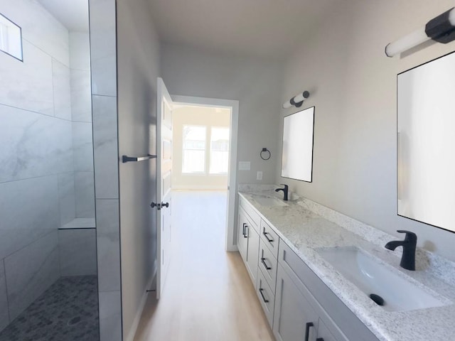 849 Cypress Ln, Cottonwood Shores, TX 78657 - full bath with double vanity, a tile shower, and wood finished floors