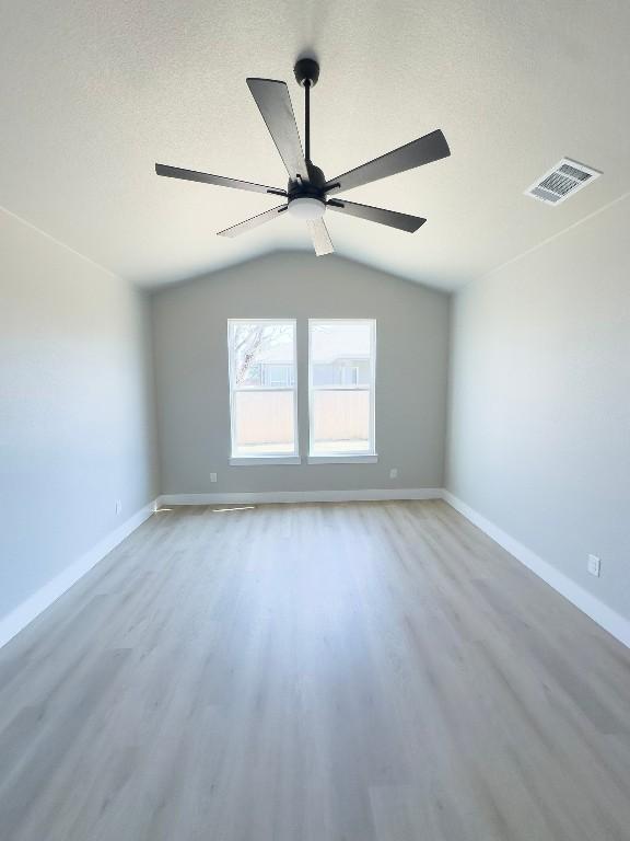849 Cypress Ln, Cottonwood Shores, TX 78657 - empty room with wood finished floors, vaulted ceiling, and a ceiling fan