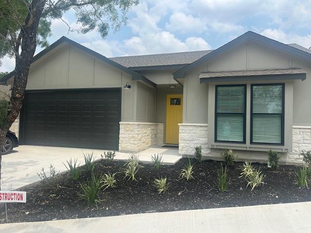 849 Cypress Ln, Cottonwood Shores, TX 78657 - view of front of house featuring stone siding, an attached garage, and driveway