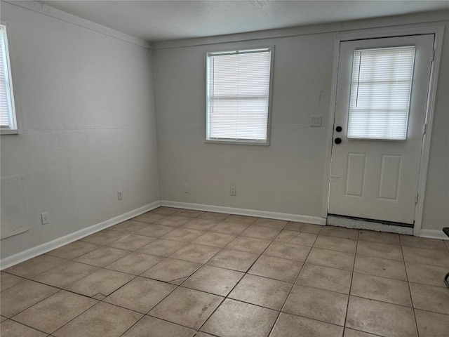 entryway featuring baseboards and light tile patterned floors