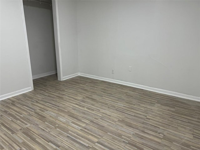 unfurnished bedroom with wood finished floors and a closet