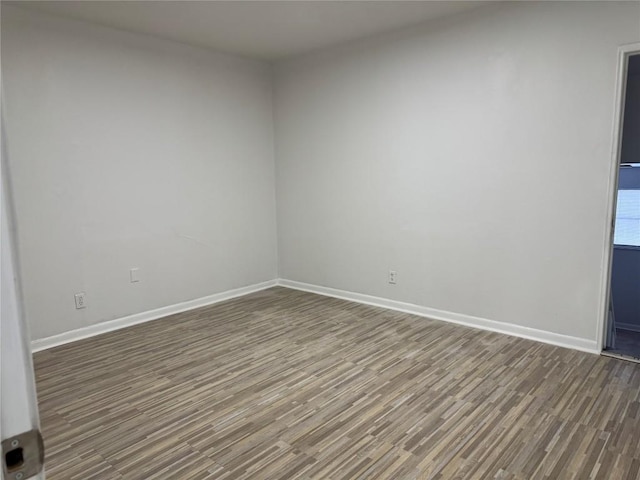 spare room with wood finished floors and baseboards