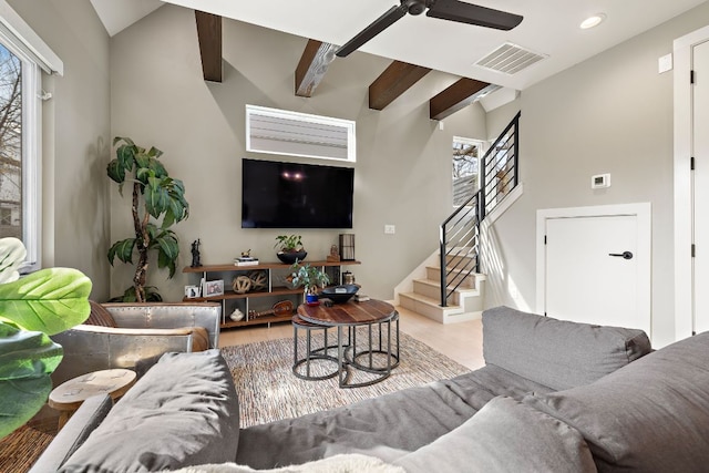 living area with a healthy amount of sunlight, stairs, visible vents, and beam ceiling