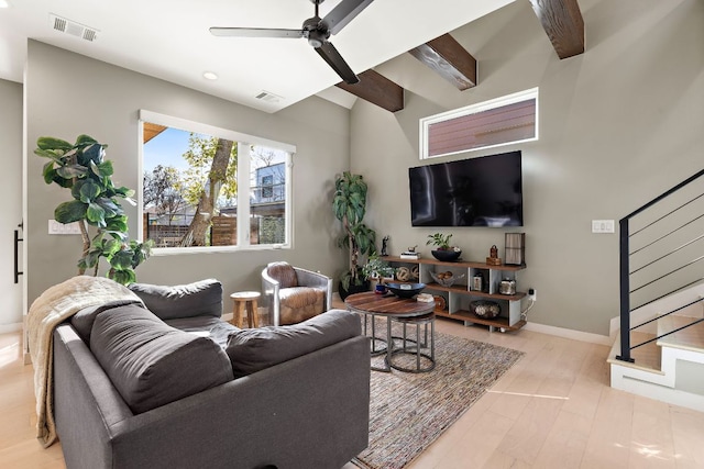 living area with stairs, wood finished floors, visible vents, and a ceiling fan