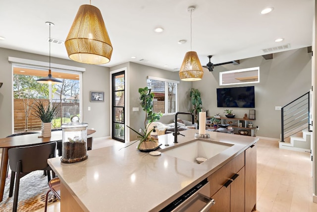 kitchen with open floor plan, stainless steel dishwasher, a sink, and visible vents