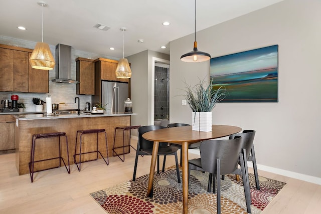 dining room featuring light wood finished floors, recessed lighting, visible vents, and baseboards