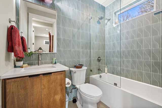 full bathroom featuring tile walls, tasteful backsplash, toilet, vanity, and  shower combination