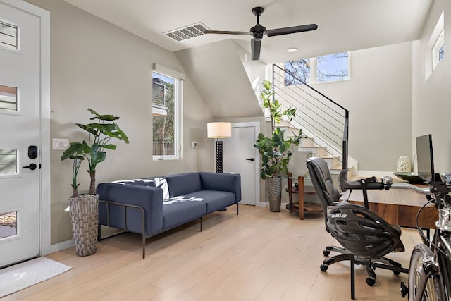 office area featuring lofted ceiling, light wood-style floors, visible vents, and a ceiling fan