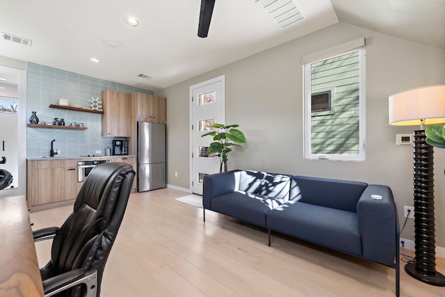 office featuring visible vents, ceiling fan, a sink, and light wood finished floors