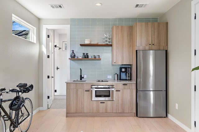 kitchen featuring light countertops, appliances with stainless steel finishes, a sink, and visible vents