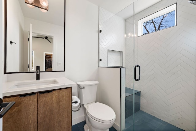 bathroom with toilet, a stall shower, a ceiling fan, and vanity