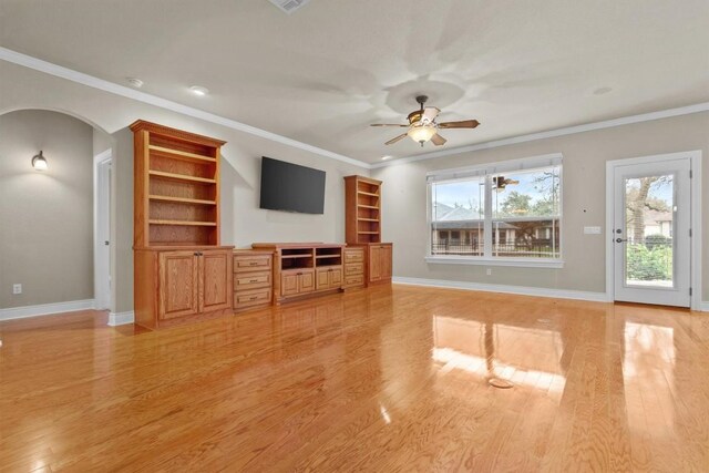 unfurnished living room with light wood-style floors, ceiling fan, arched walkways, and baseboards