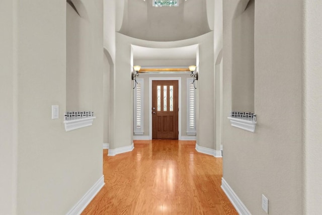 entryway featuring a high ceiling, wood finished floors, and baseboards