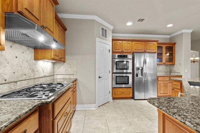 kitchen featuring light tile patterned floors, stainless steel appliances, visible vents, dark stone countertops, and under cabinet range hood