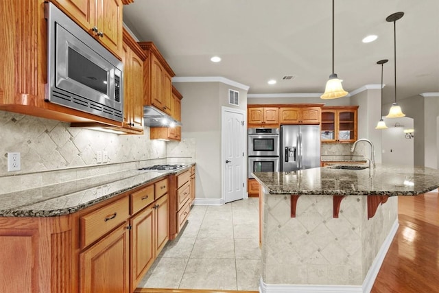 kitchen featuring visible vents, crown molding, appliances with stainless steel finishes, and a sink