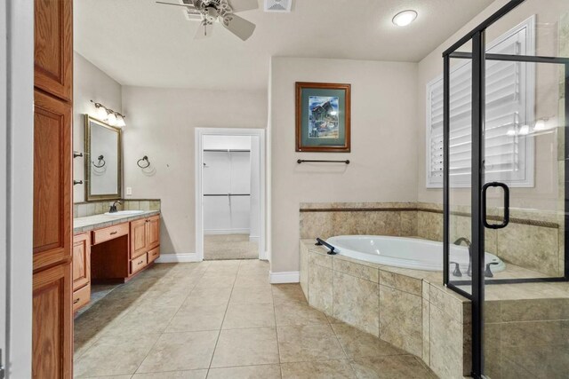 full bath featuring a stall shower, tile patterned floors, a walk in closet, vanity, and a bath