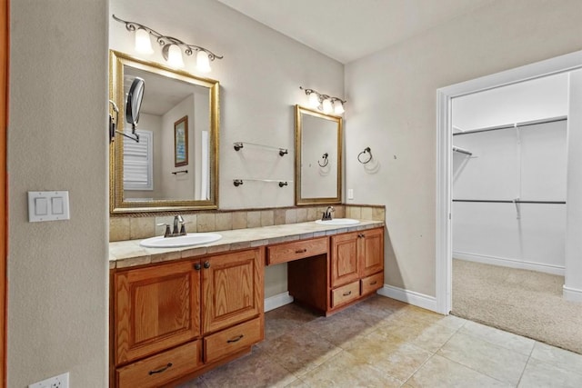 full bathroom featuring double vanity, a spacious closet, a sink, and tile patterned floors