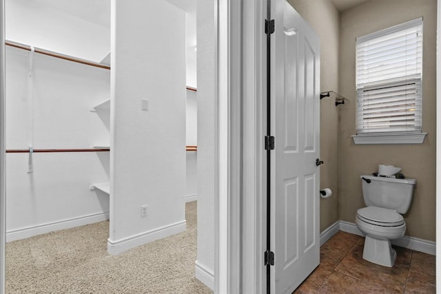 bathroom featuring baseboards and toilet