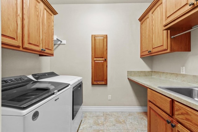 laundry room with separate washer and dryer, light tile patterned flooring, cabinet space, and baseboards