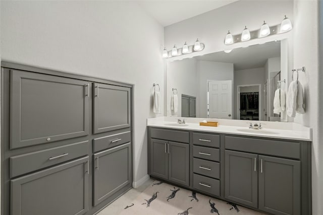 bathroom with double vanity, a closet, and a sink