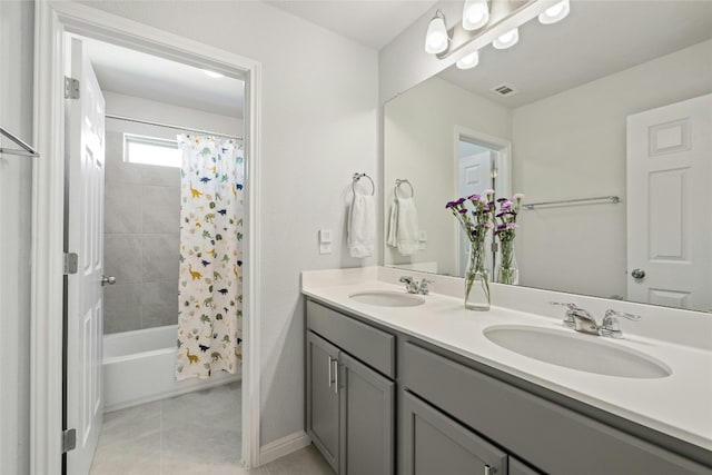 bathroom featuring double vanity, shower / bath combo with shower curtain, a sink, and tile patterned floors