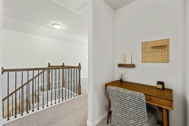 hallway featuring carpet, baseboards, and an upstairs landing