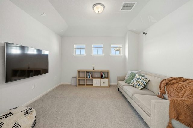 living room featuring lofted ceiling, baseboards, light carpet, and visible vents