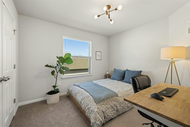 carpeted bedroom featuring an inviting chandelier and baseboards