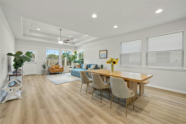 dining area featuring a tray ceiling, light wood finished floors, recessed lighting, ceiling fan, and baseboards