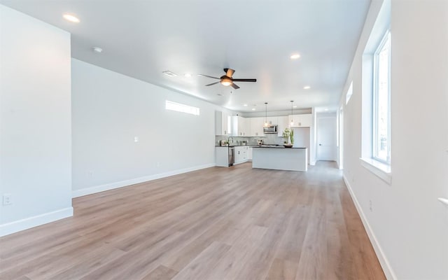 unfurnished living room with light wood finished floors, baseboards, a ceiling fan, and recessed lighting