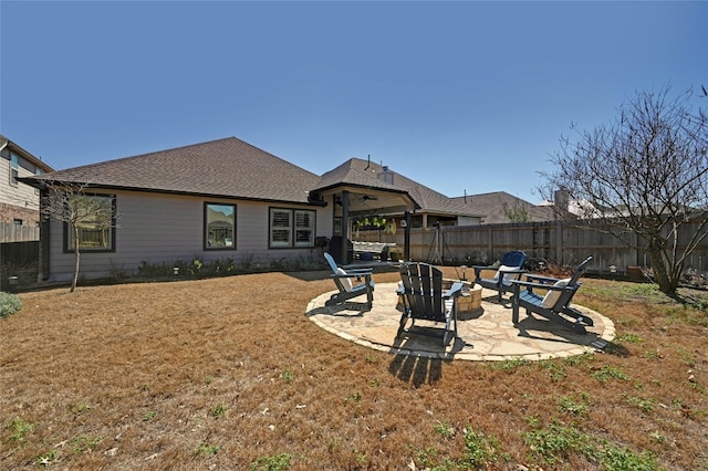 back of property featuring a yard, an outdoor fire pit, a patio area, and a fenced backyard