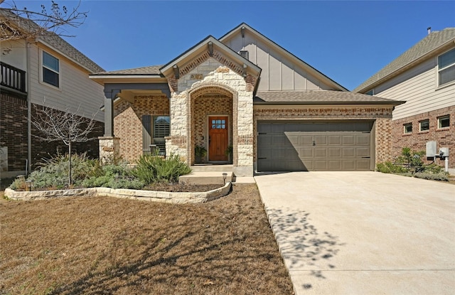 view of front of home with board and batten siding, brick siding, driveway, and a garage