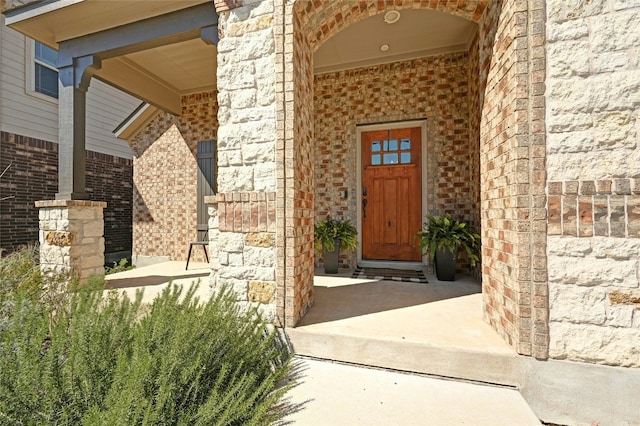 view of exterior entry with brick siding