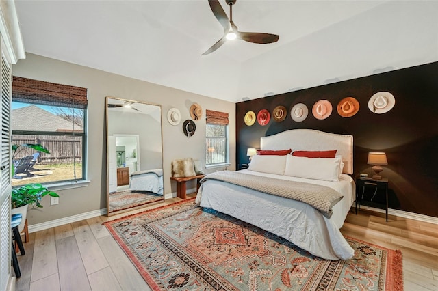 bedroom featuring vaulted ceiling, ceiling fan, light wood-type flooring, and baseboards