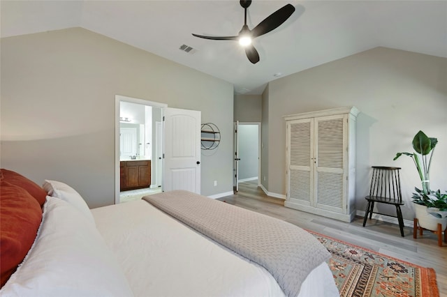 bedroom featuring light wood-style floors, vaulted ceiling, and baseboards