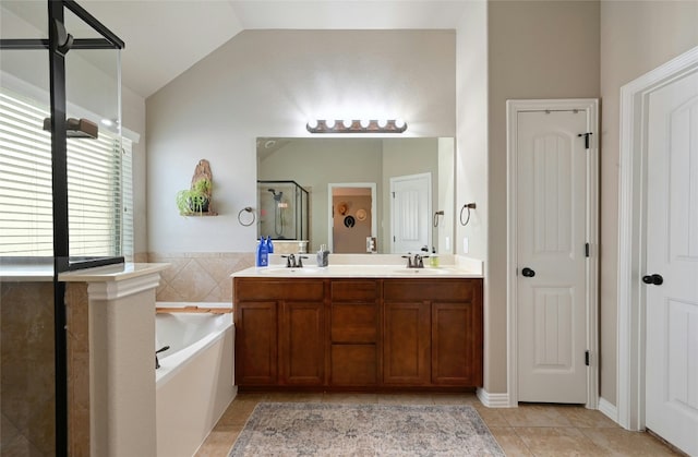 bathroom featuring a closet, vaulted ceiling, a sink, a shower stall, and tile patterned floors
