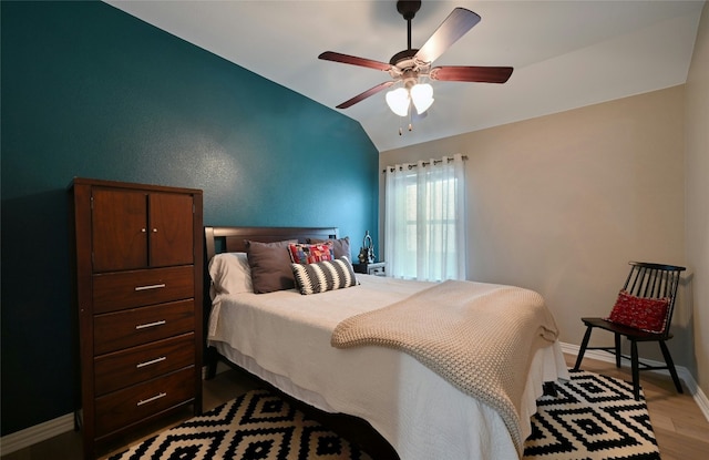 bedroom with lofted ceiling, light wood-style flooring, baseboards, and ceiling fan