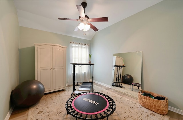 workout room with lofted ceiling, ceiling fan, light wood finished floors, and baseboards