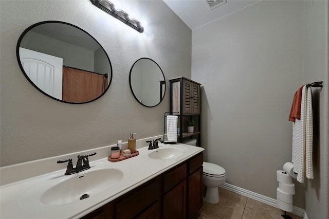 full bathroom featuring double vanity, a sink, toilet, and tile patterned floors