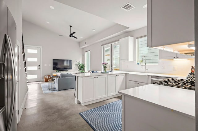 kitchen with open floor plan, visible vents, finished concrete floors, ceiling fan, and stainless steel fridge with ice dispenser