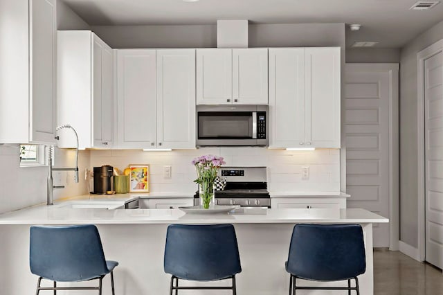 kitchen with light countertops, a breakfast bar area, and stainless steel appliances